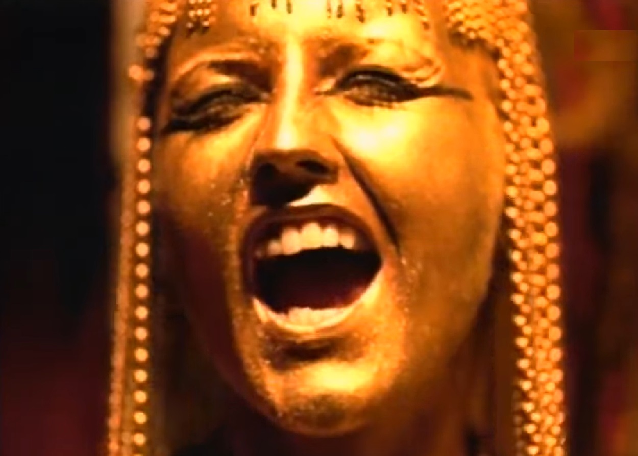 Screenshot: Dolores O'Riordan with golden hair and face singing - from Dolores (TV documentary,2018)