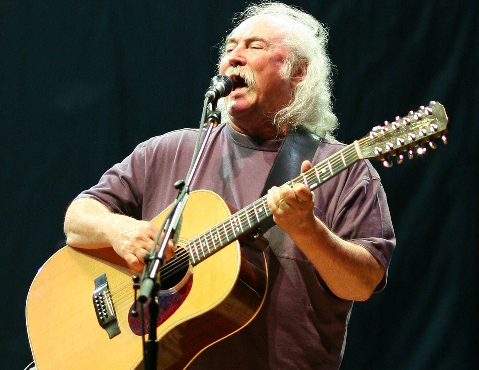 David Crosby in a 2006 performance touring with Crosby, Stills, Nash, and Young in blue t-shirt