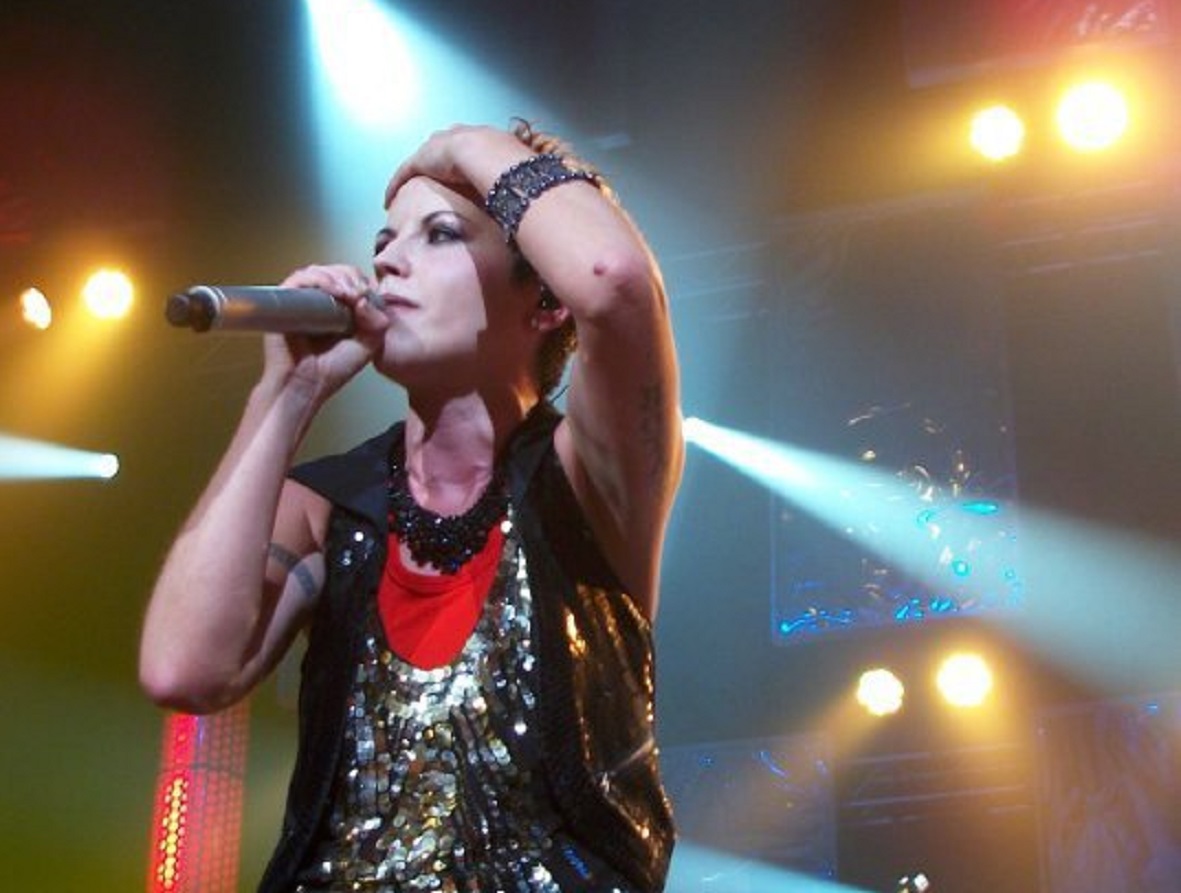 Dolores O'Riordan wearing black coat is performing live on stage - 2007.