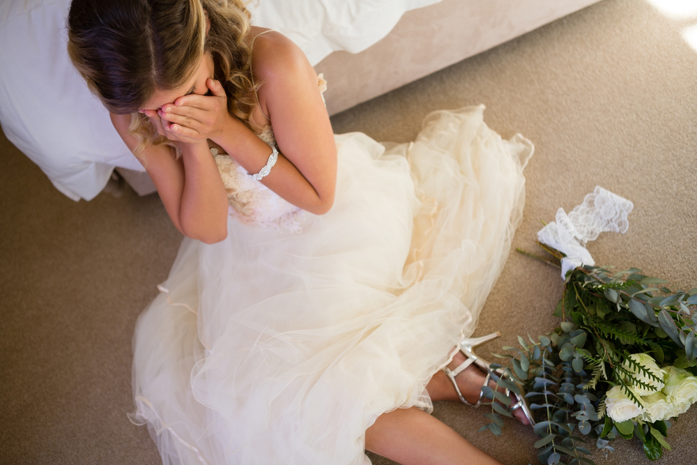 High angle view of bride in wedding dress crying