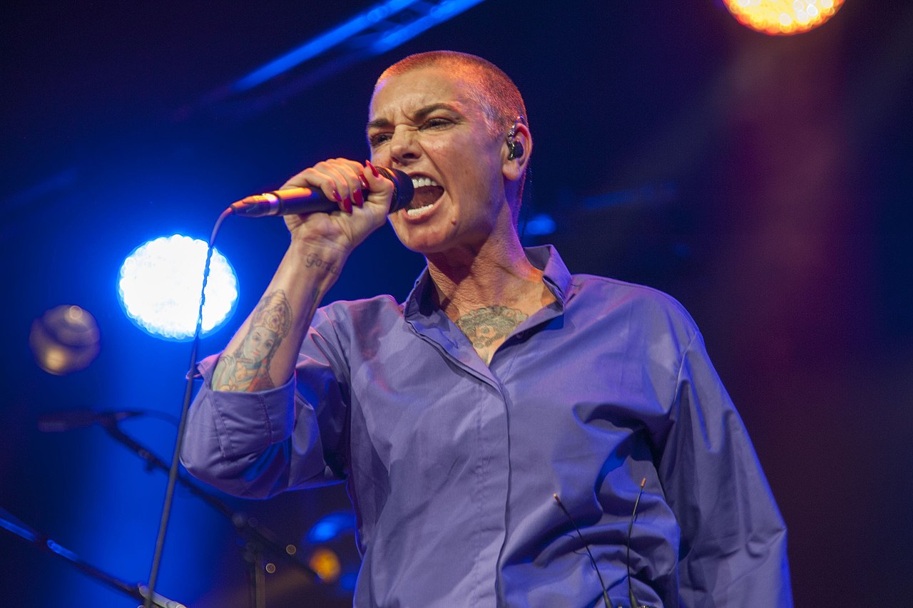 Sinead O'Connor wearing blue shirt is performing on stage live - 2014
