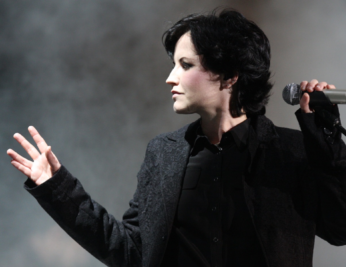 Dolores O'Riordan is performing live on stage on the grey background - 2012
