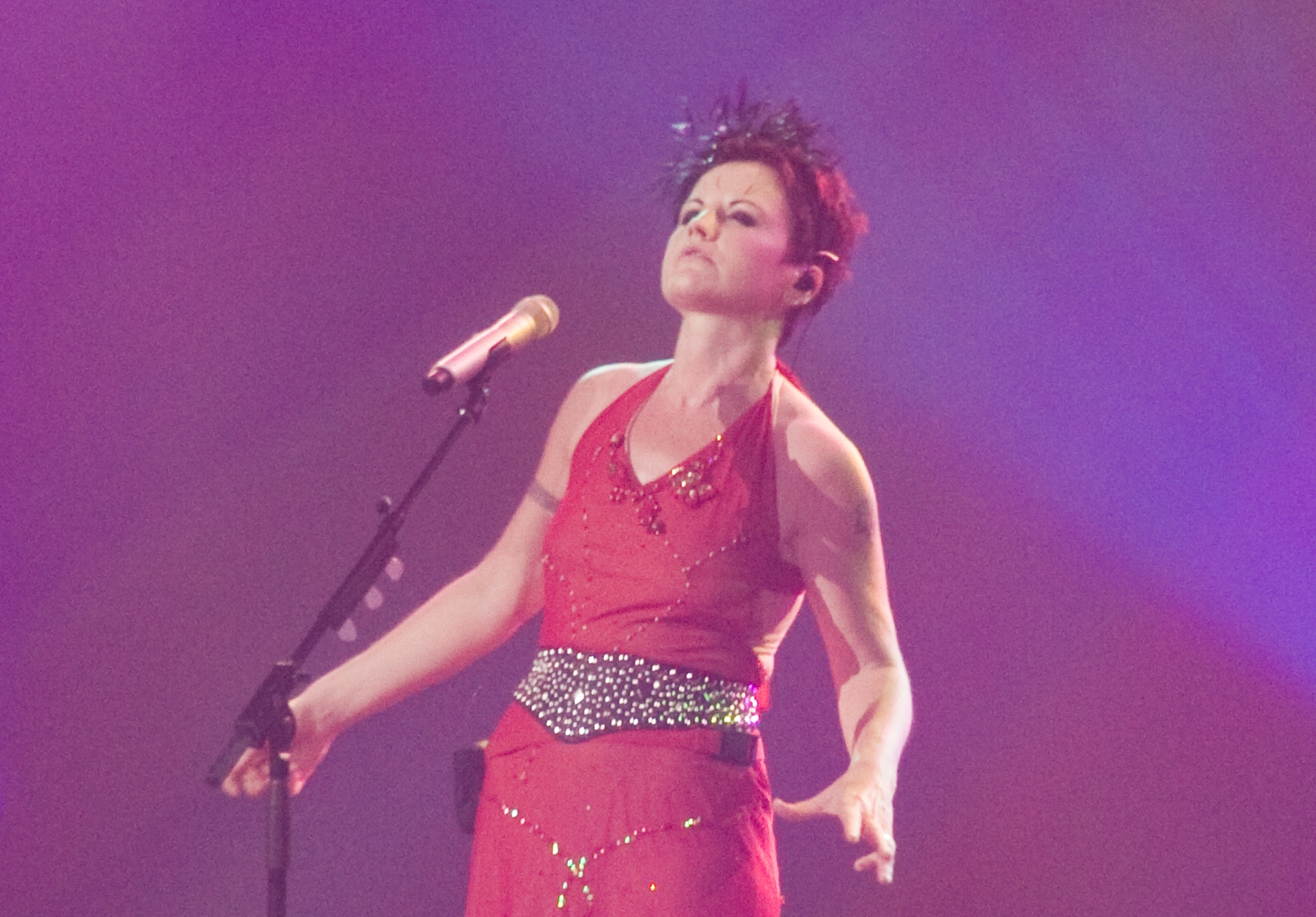 Dolores O'Riordan wearing red dress is singing on the stage - 2010