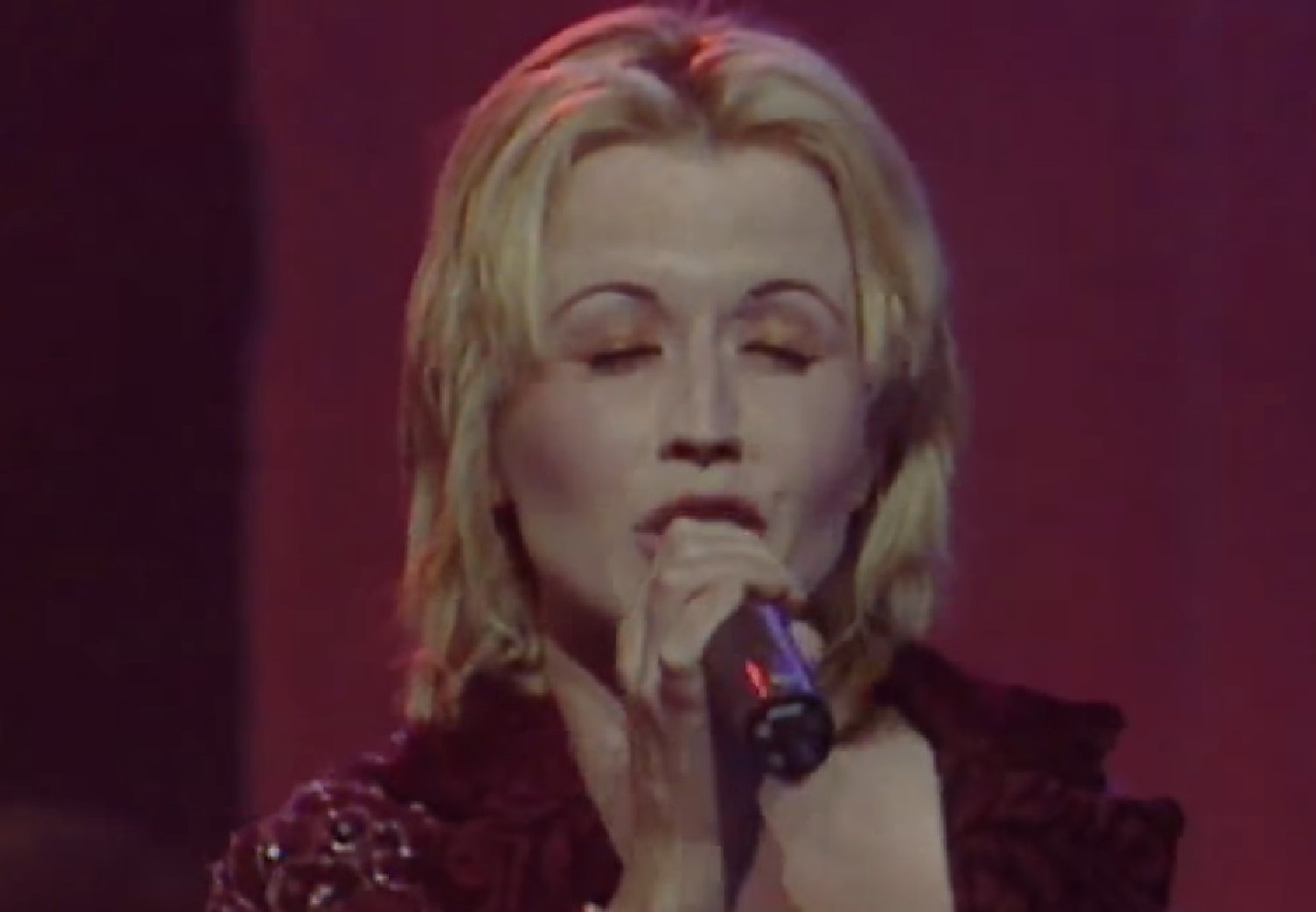 Screenshot: Dolores O'Riordan is singing on stage with closed eyes - from Dolores (TV documentary,2018)