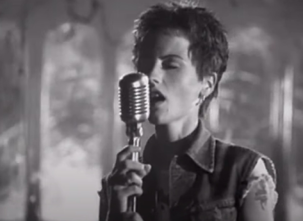 B&W Screenshot: Dolores O'Riordan singing on microphone - from Dolores (TV documentary,2018)