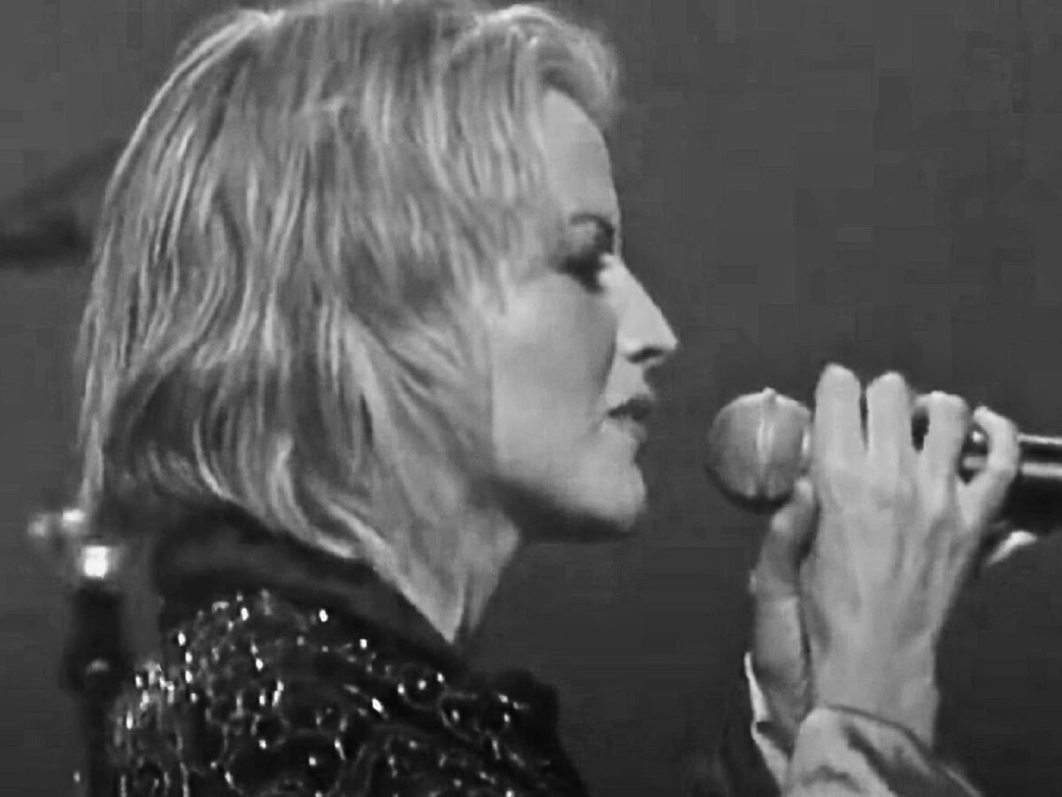 B&W Screenshot: Dolores O'Riordan wearing black shirt and singing - from Dolores (TV documentary,2018)