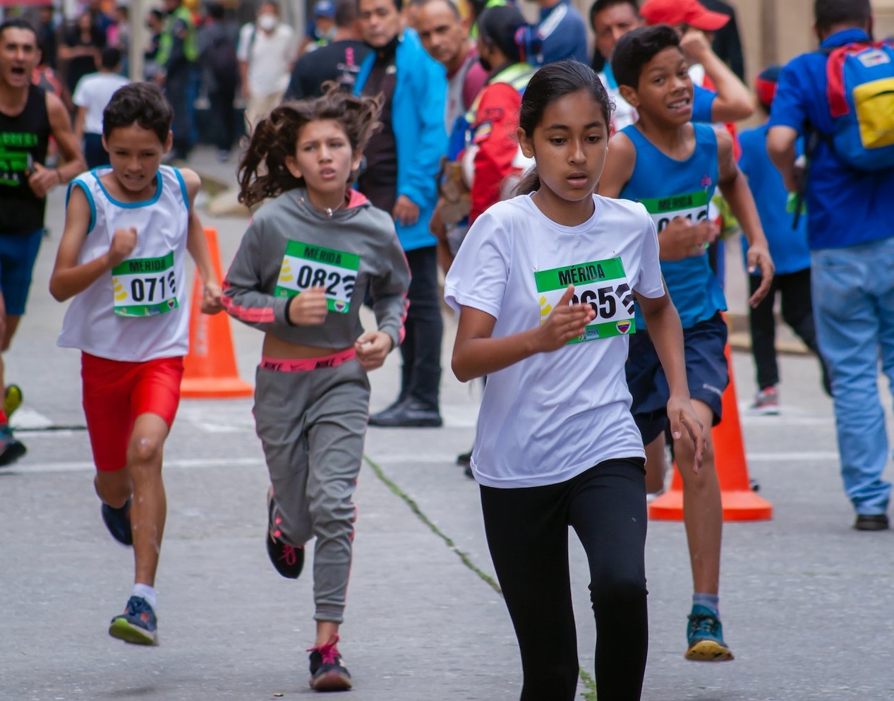 Children running in a marathon outside at street.