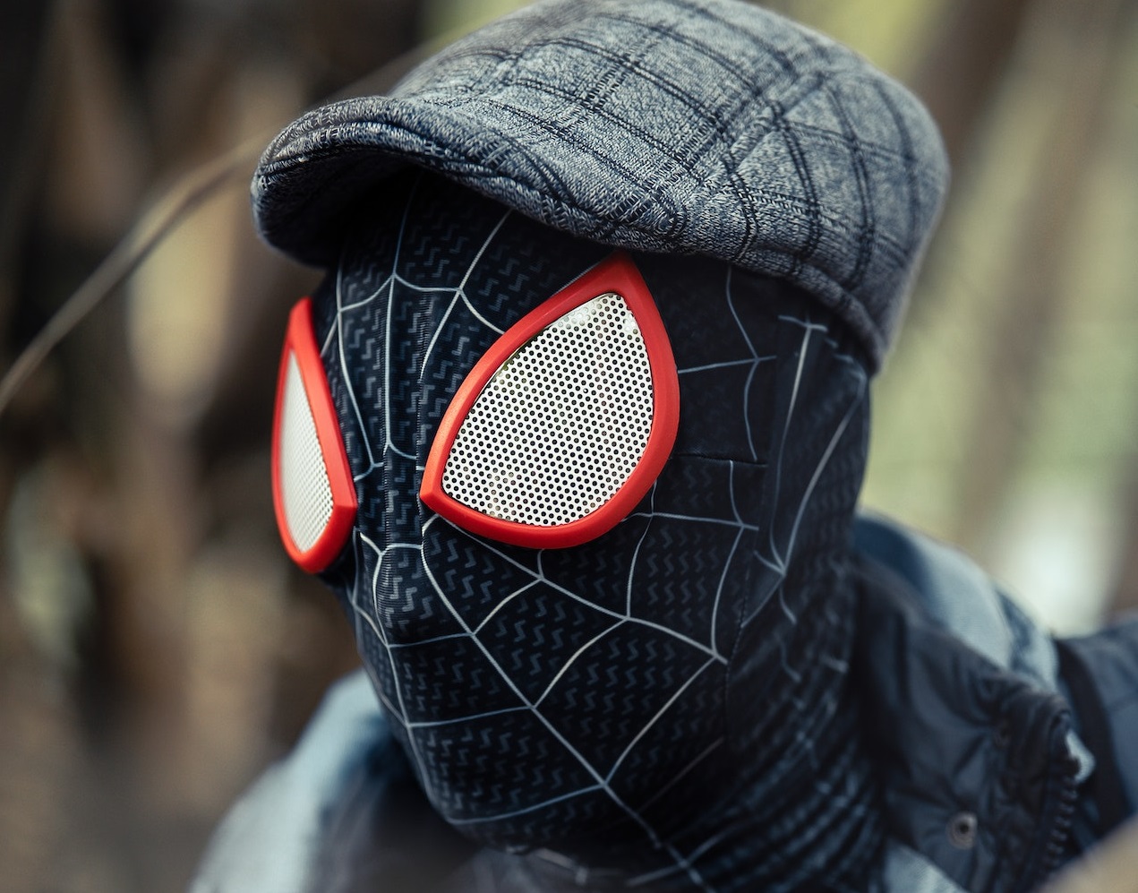 Man wearing spider-man mask and hat.