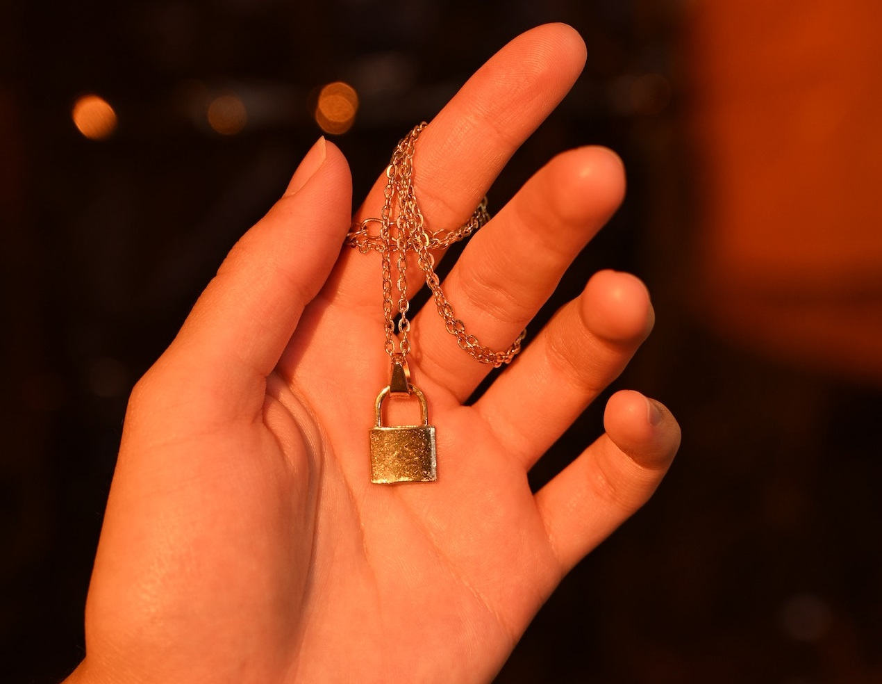 Golden necklace on her hand.