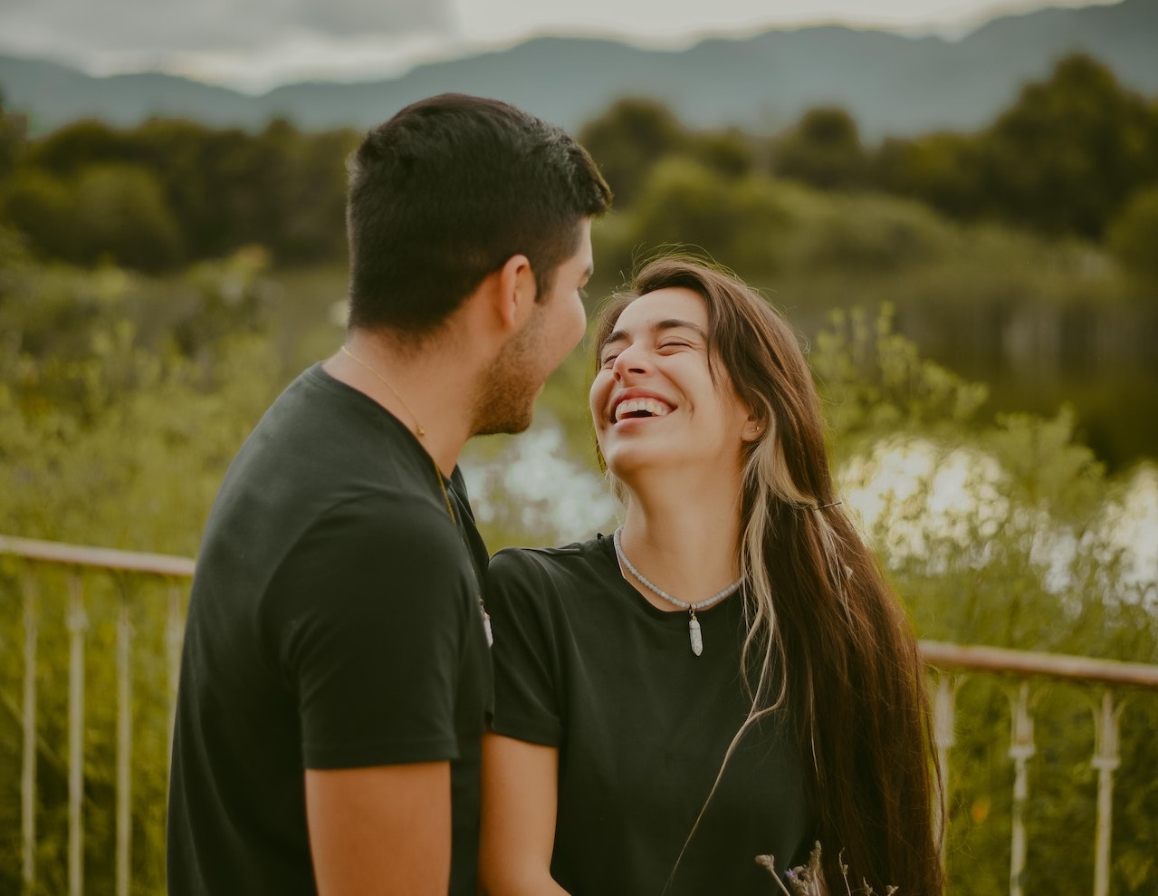 Couple are smiling outside.