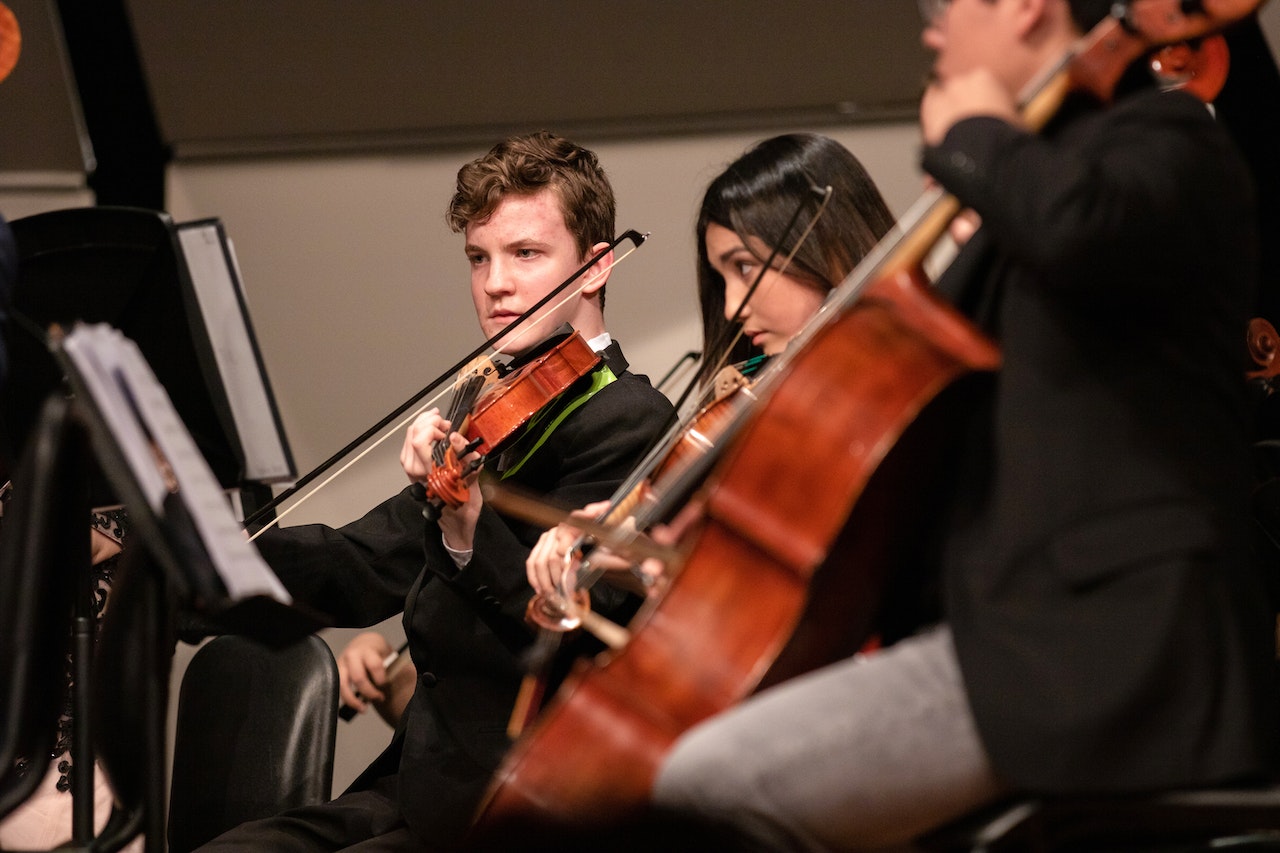 Young people are playing music rehearsal on instruments at school.