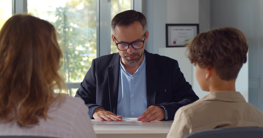 Mature male principal having meeting with student and parent