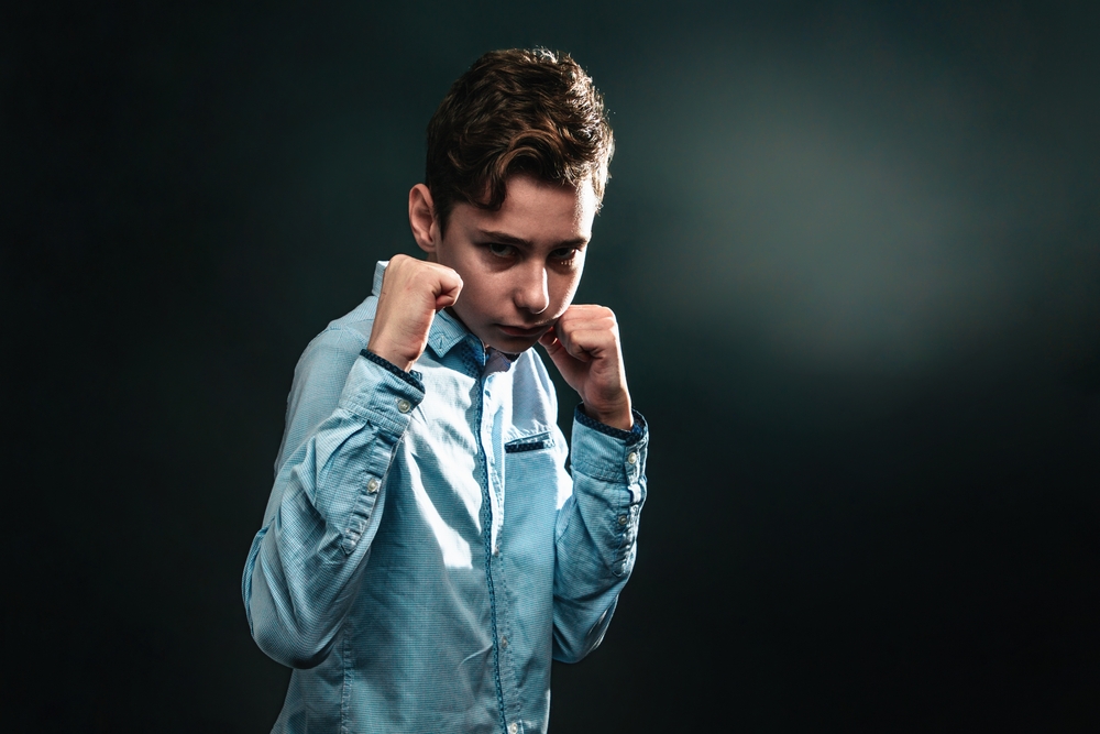 boy with clenched fists ready to defends himself against aggression