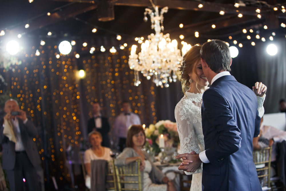 Groom holds bride's hand and  dance  with her