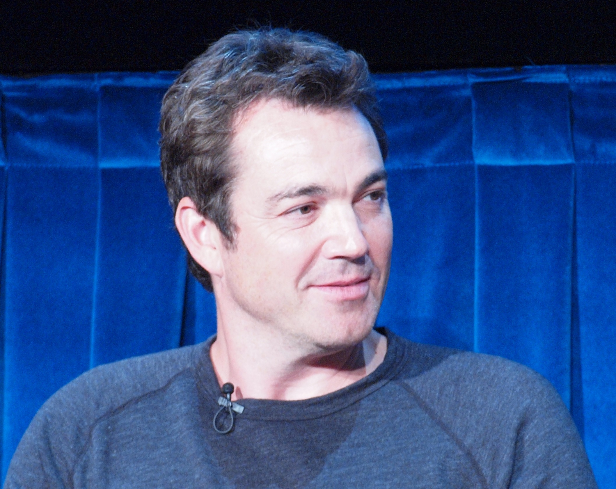 Jon Tenney  wearing blue sweater is looking at side - 2011