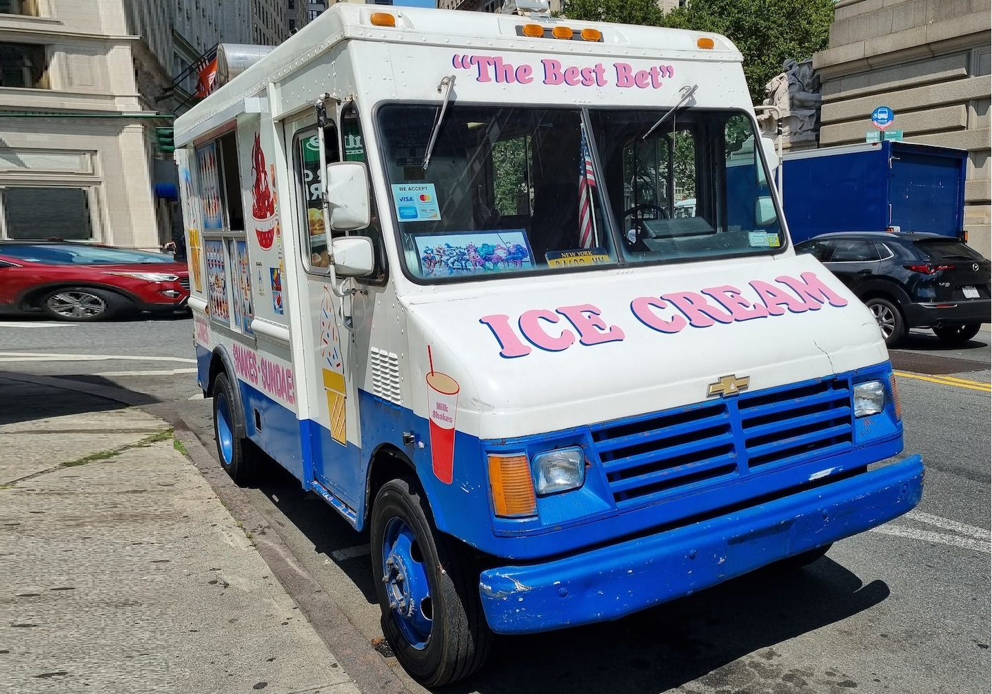 White and blue ice cream van parked on the street.