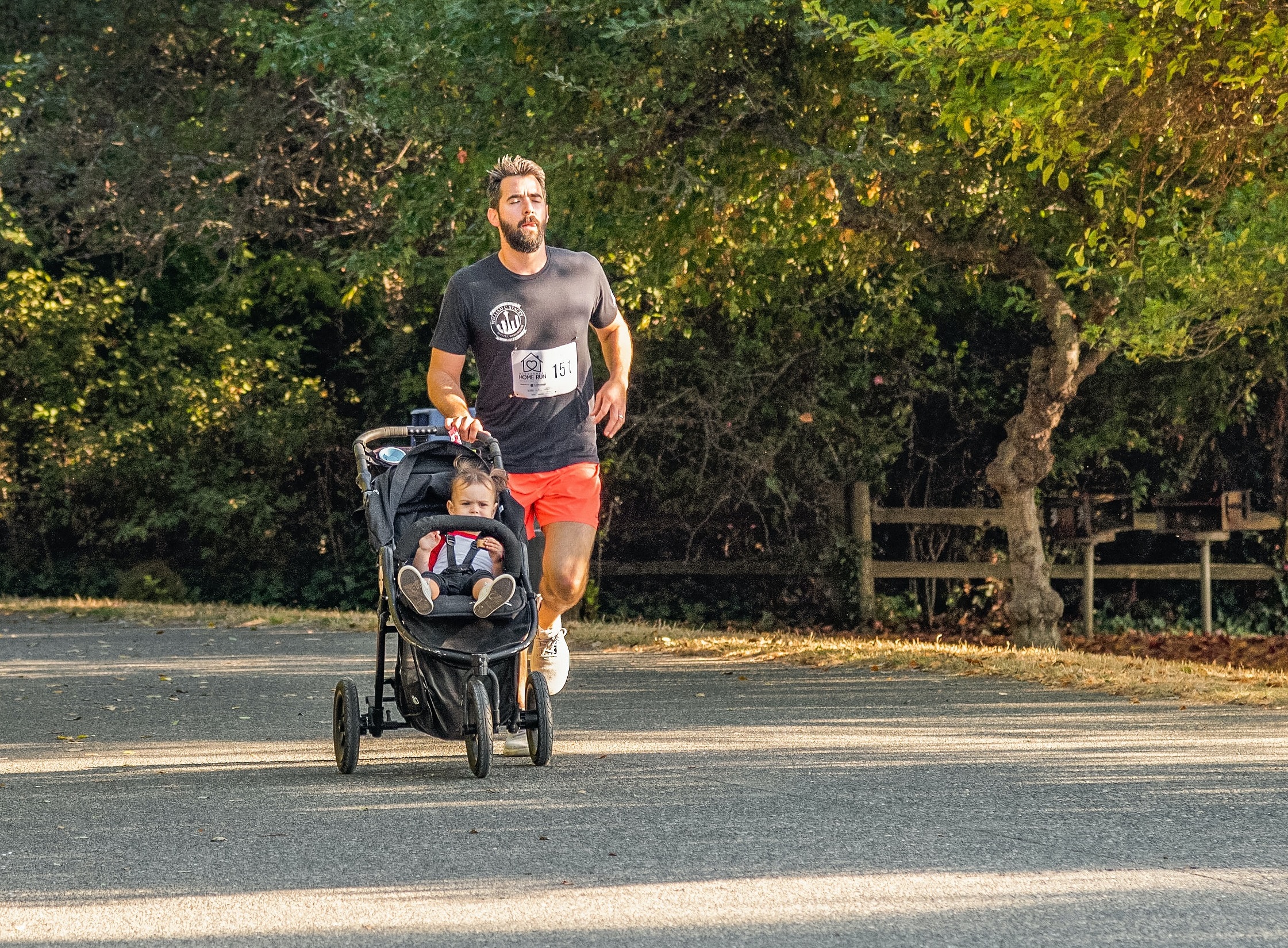 Man is running with a baby in a stroller.
