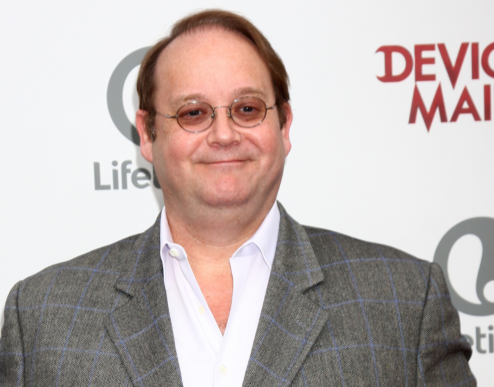 Marc Cherry wearing white shirt and grey jacket is looking at side and smiling - 2013