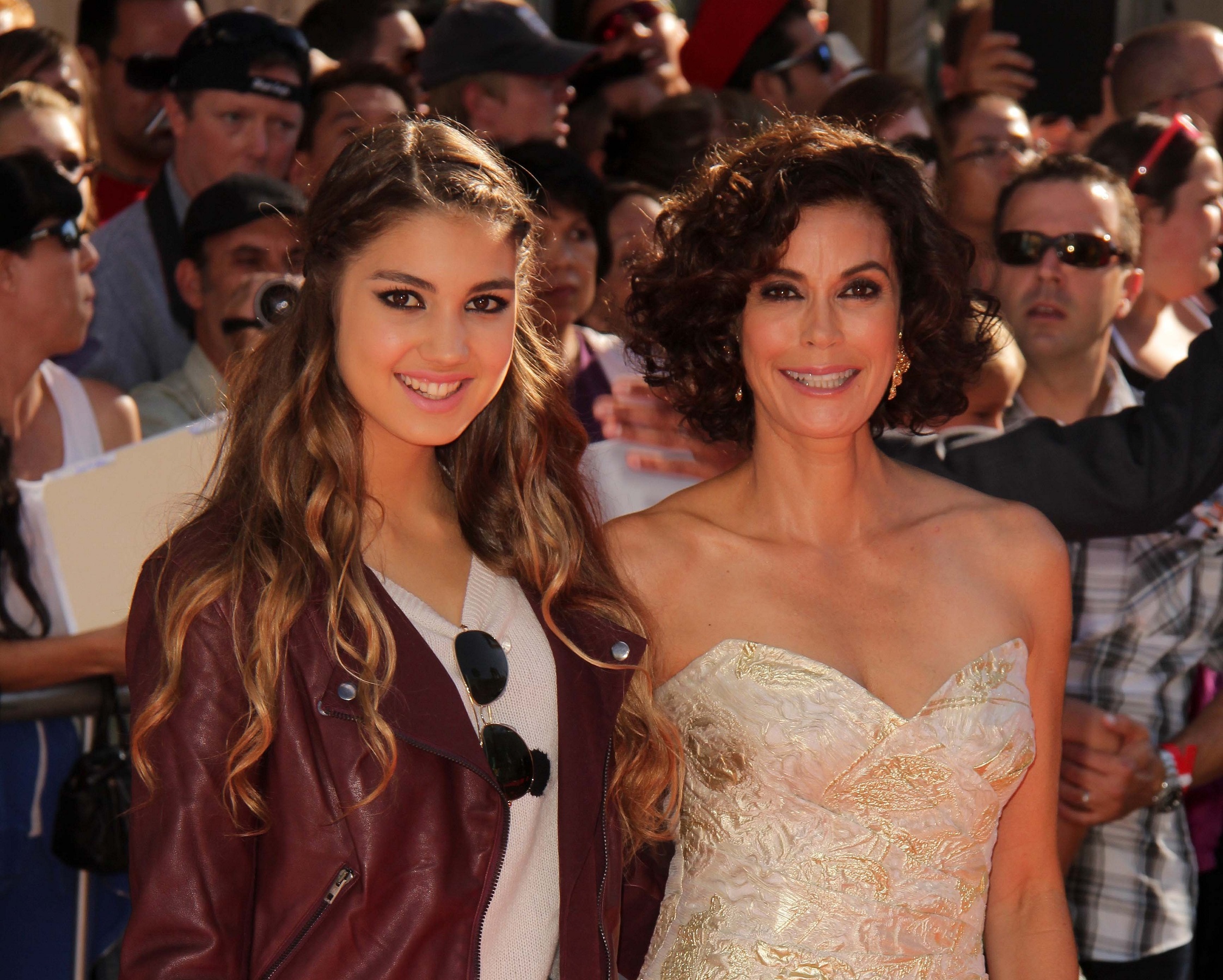 Teri Hatcher in white dress with her daughter Emerson wearing red leather jacket are looking at camera and smiling - 2013