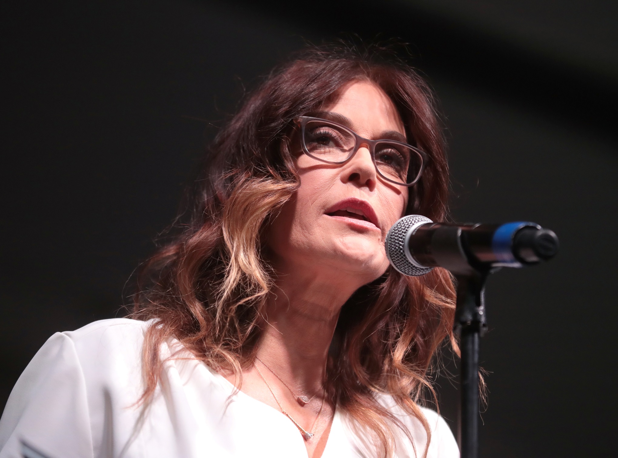 Teri Hatcher speaking at microphone wearing white dress and glasses,looking at side - 2019