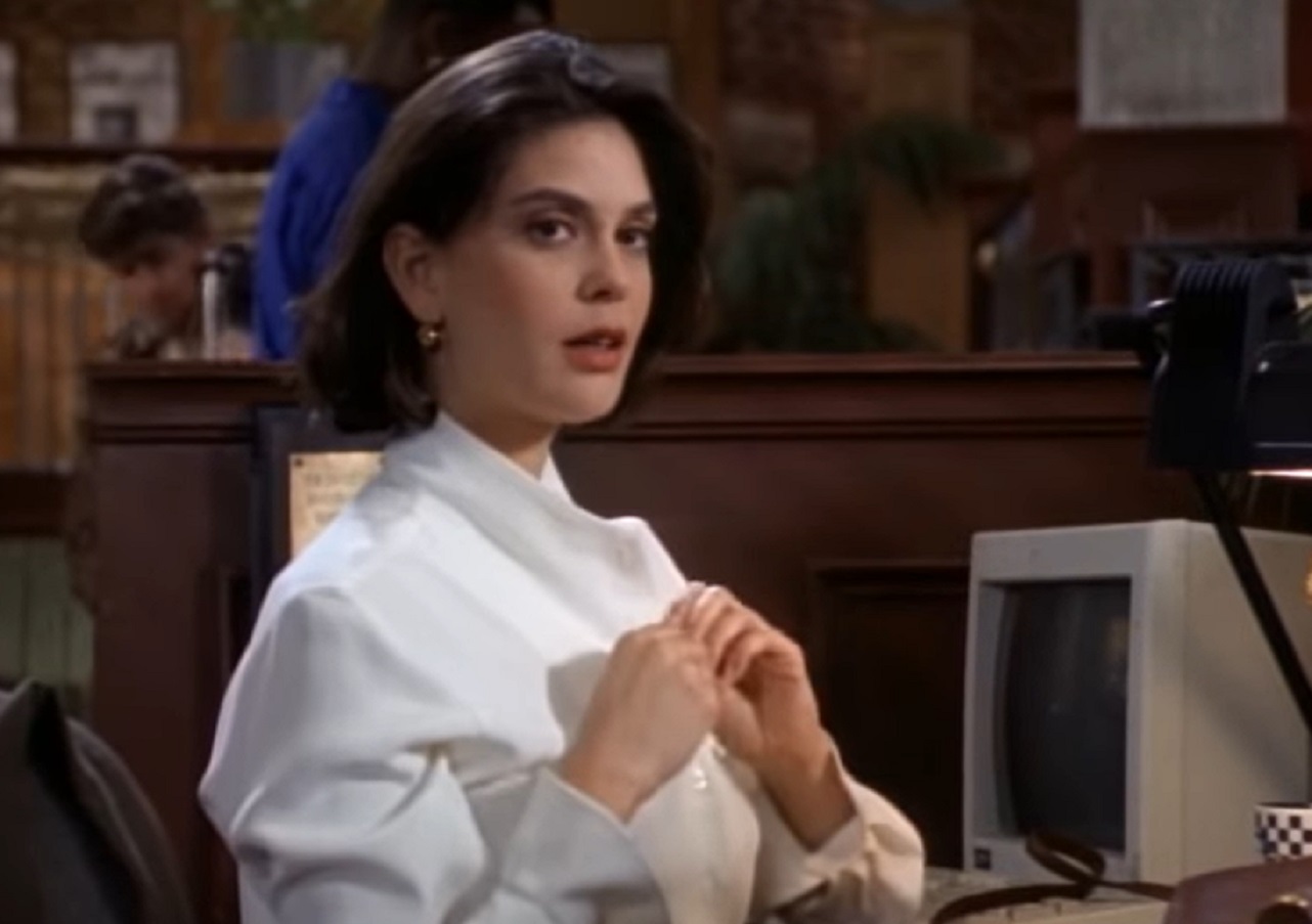 Screenshot: Teri Hatcher seating on her desk and looking at camera  - from Lois & Clark  (1993-97)