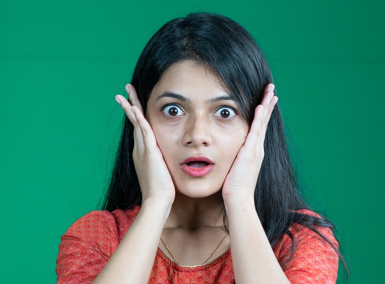 Woman is making a shocked face looking at camera.