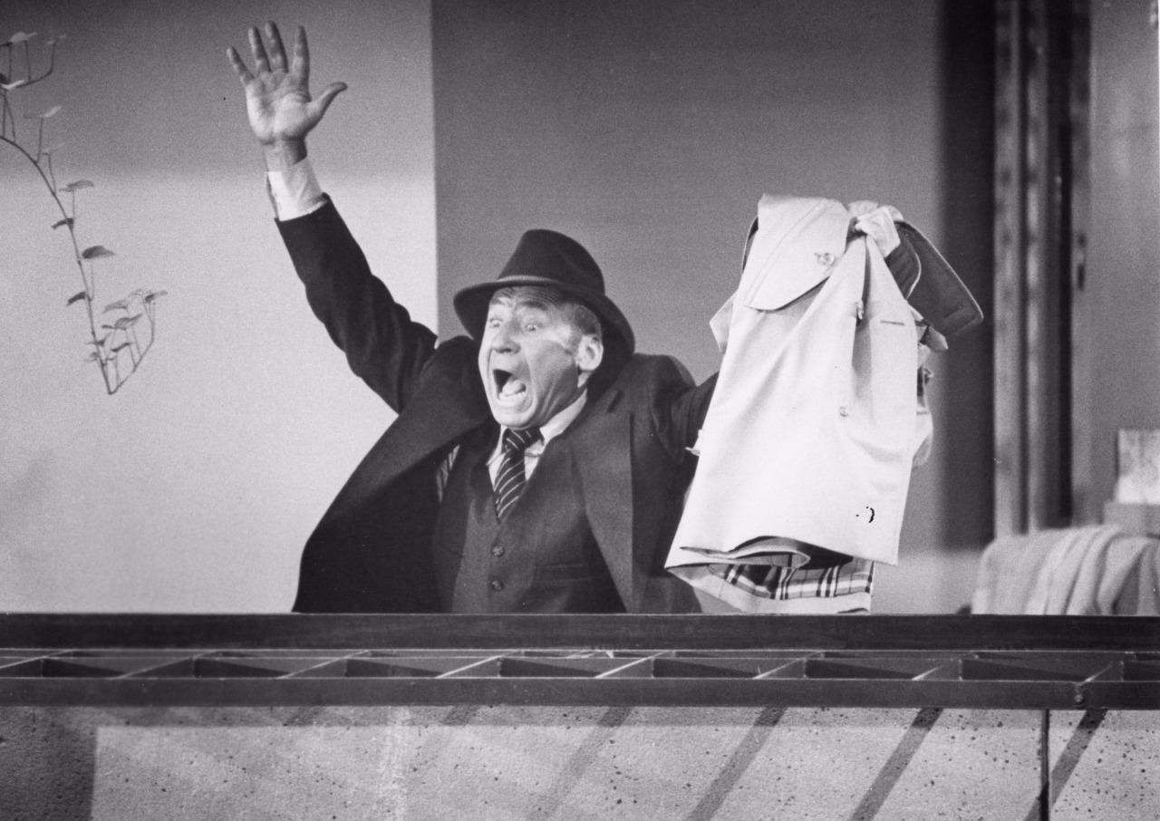 Mel Brooks in American satirical comedy film High Anxiety (1977) yelling with raised hand in suit and