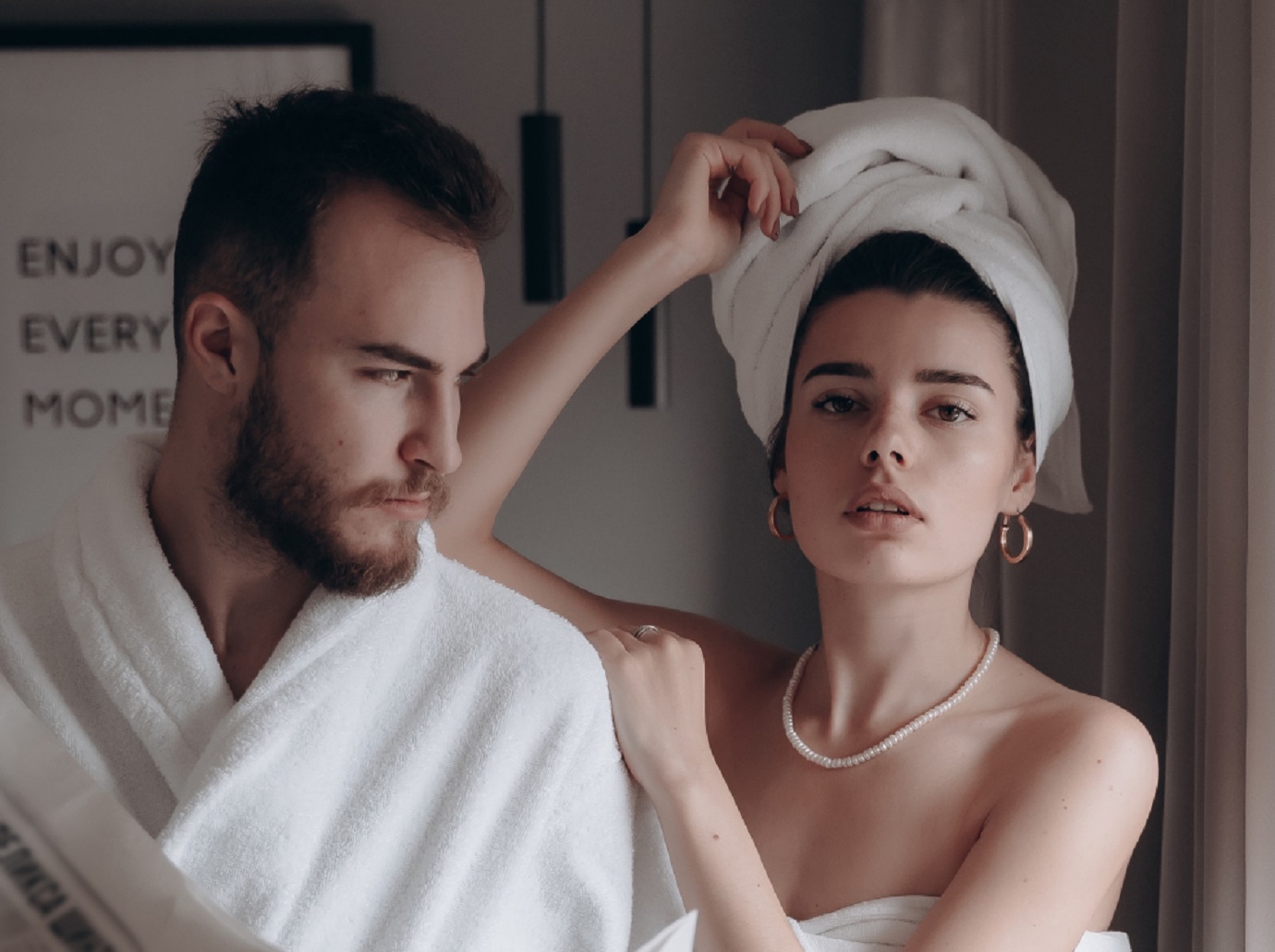 Man in white towel is looking upset to a woman.