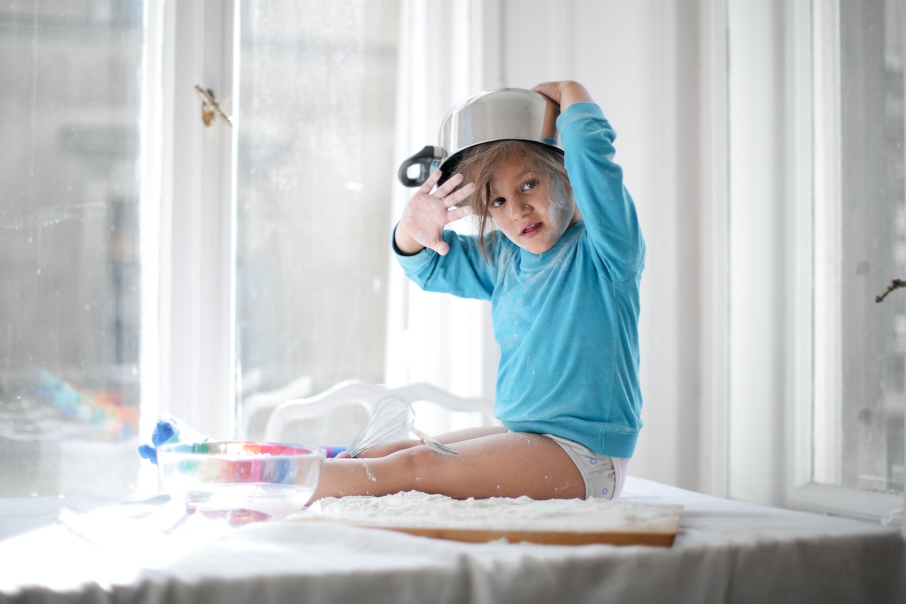 Small kid making mess in the kitchen.