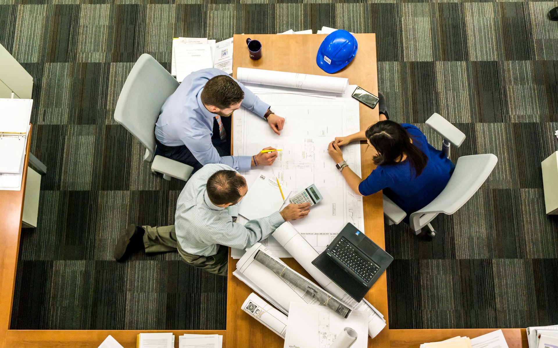 Architects sitting on a desk with plans