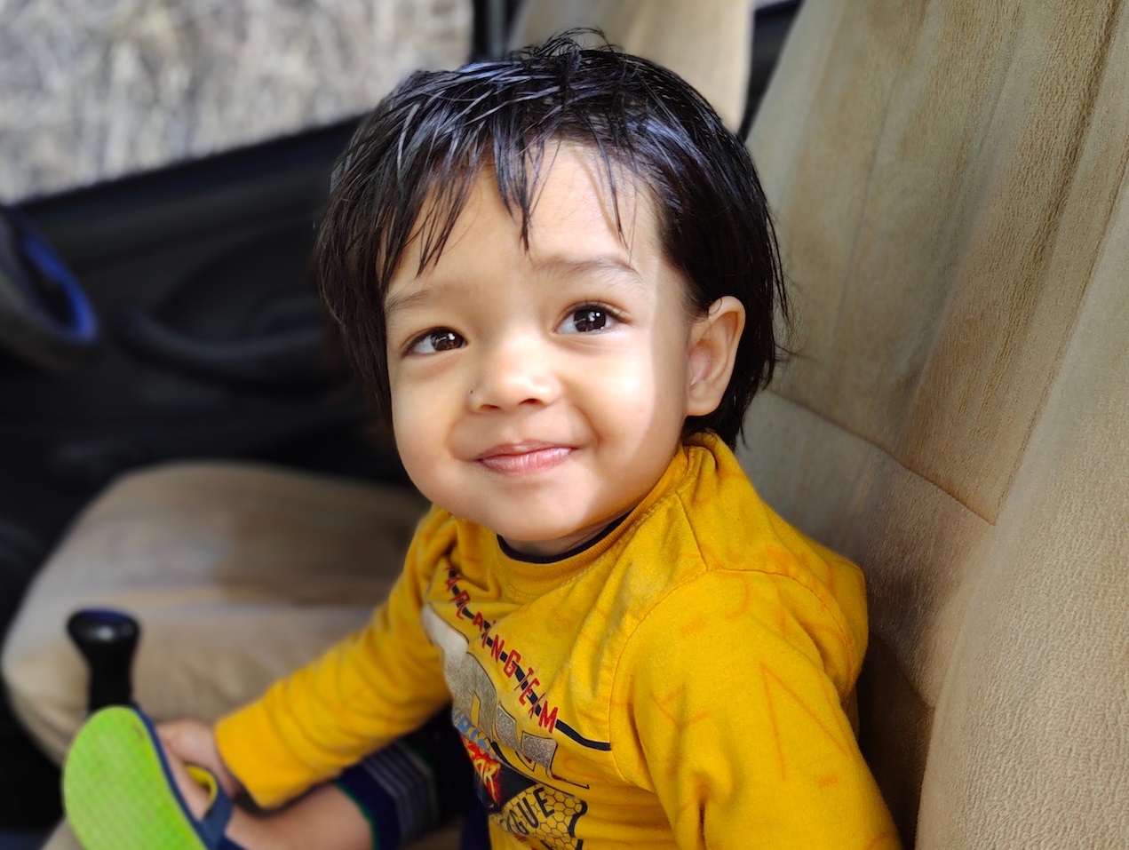 Small smiling kid in the car.