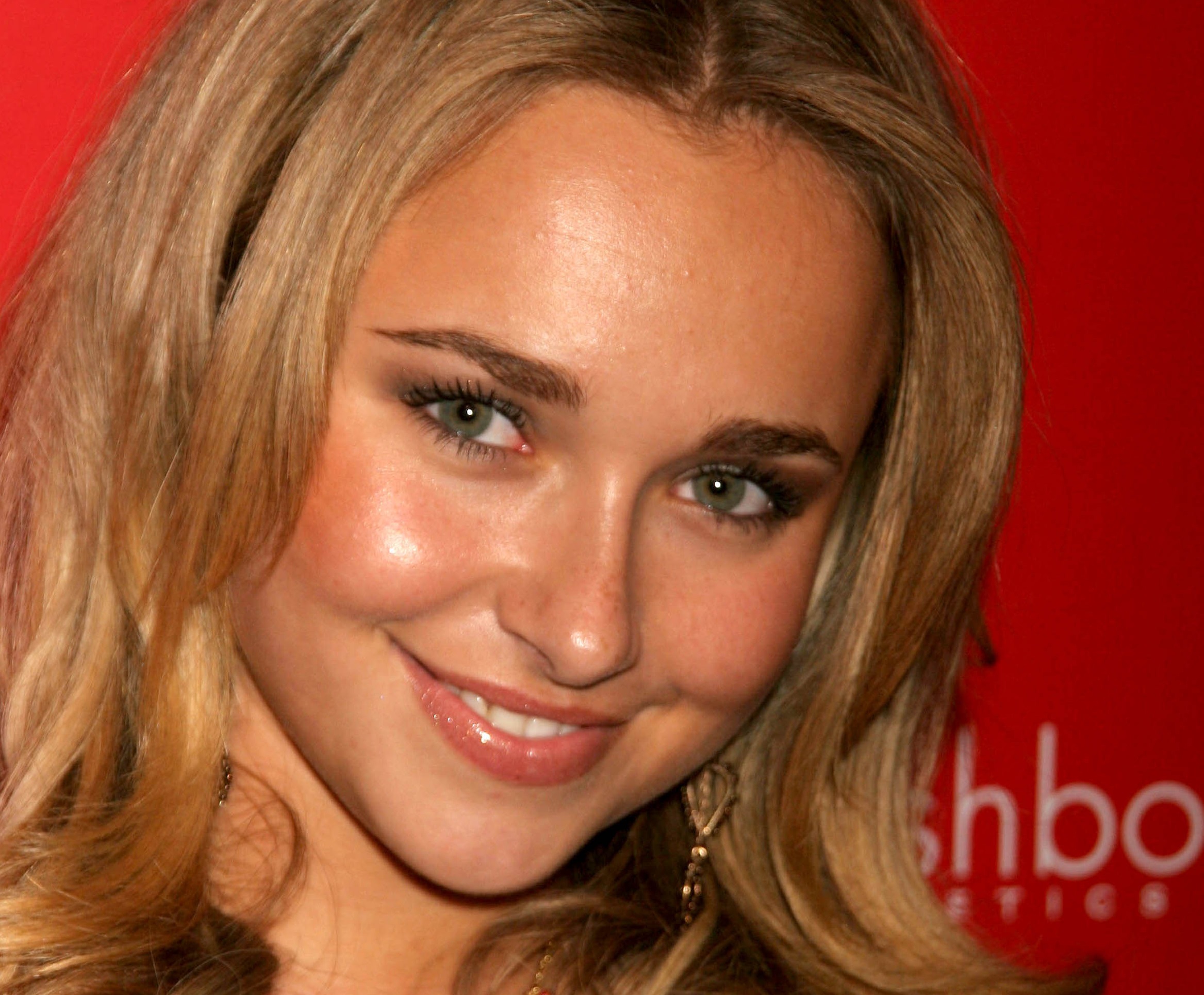 Hayden Panettiere wearing red dress, smiling and looking at camera on red background - 2006