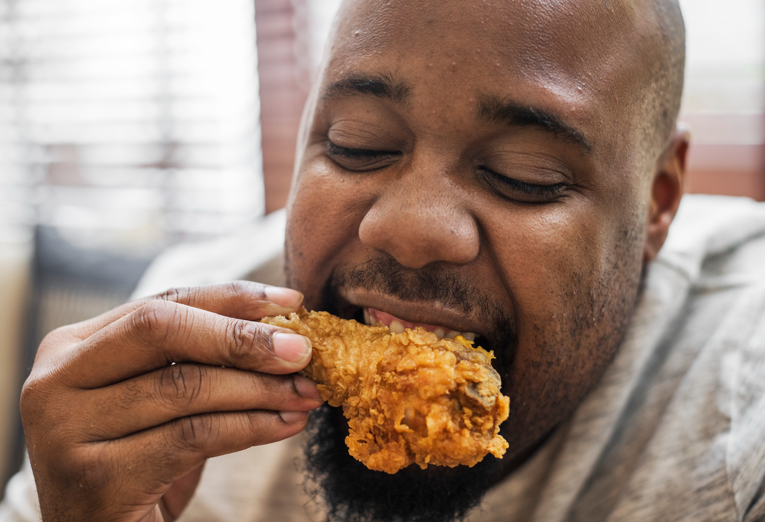 Black man eating chicken wings.