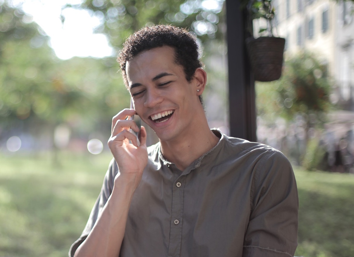 Man singing on the phone outside.
