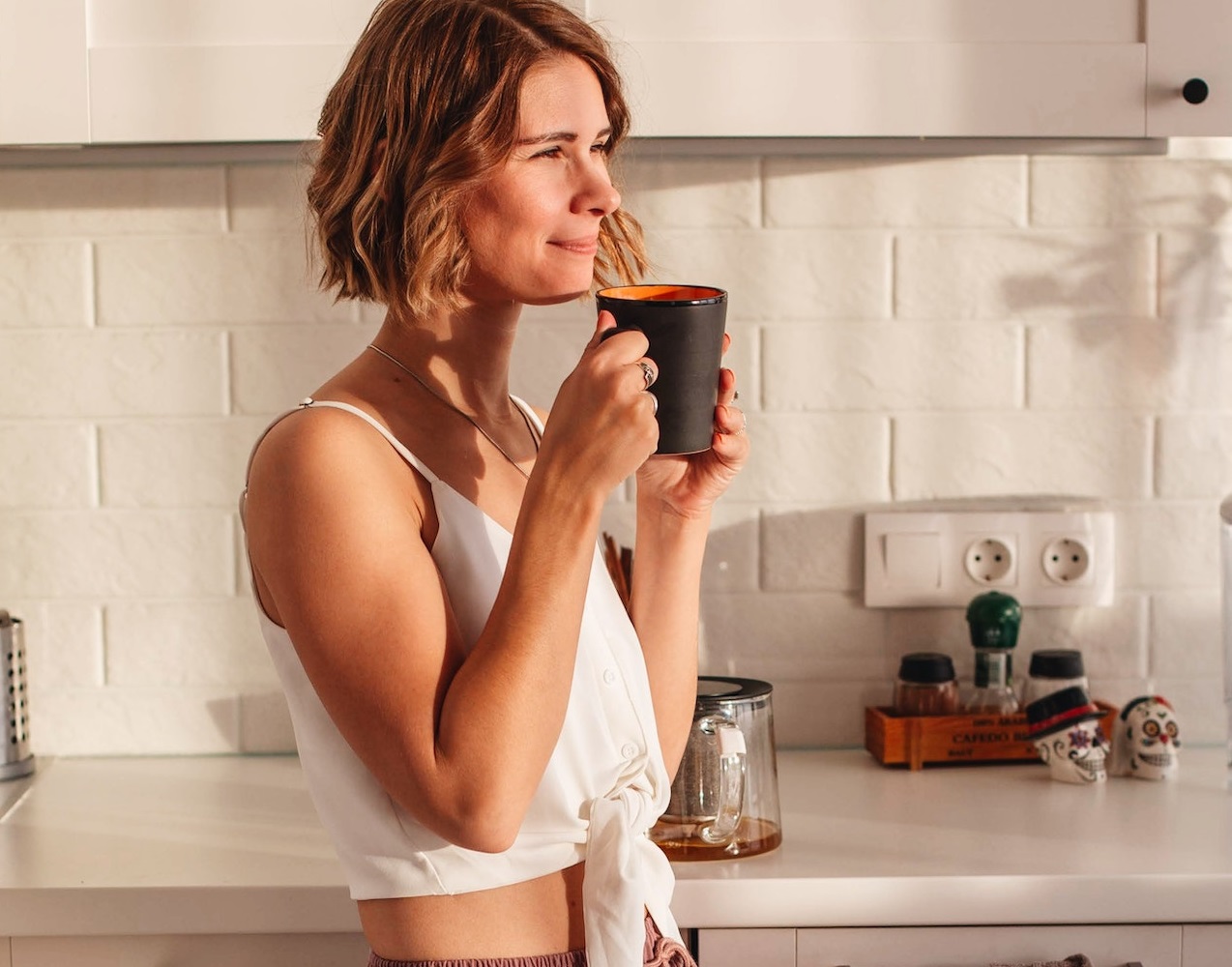 Woman drinking coffee in the kitchen.