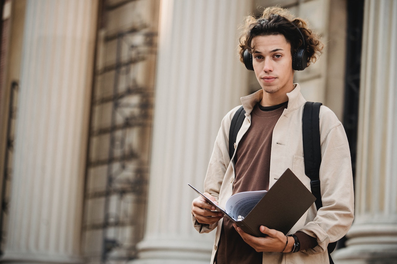 Man with backpack holding a papers.