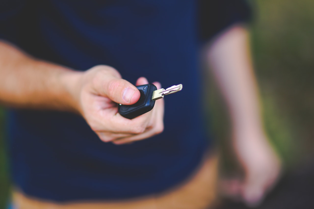 Man holding a black car key in his hand.