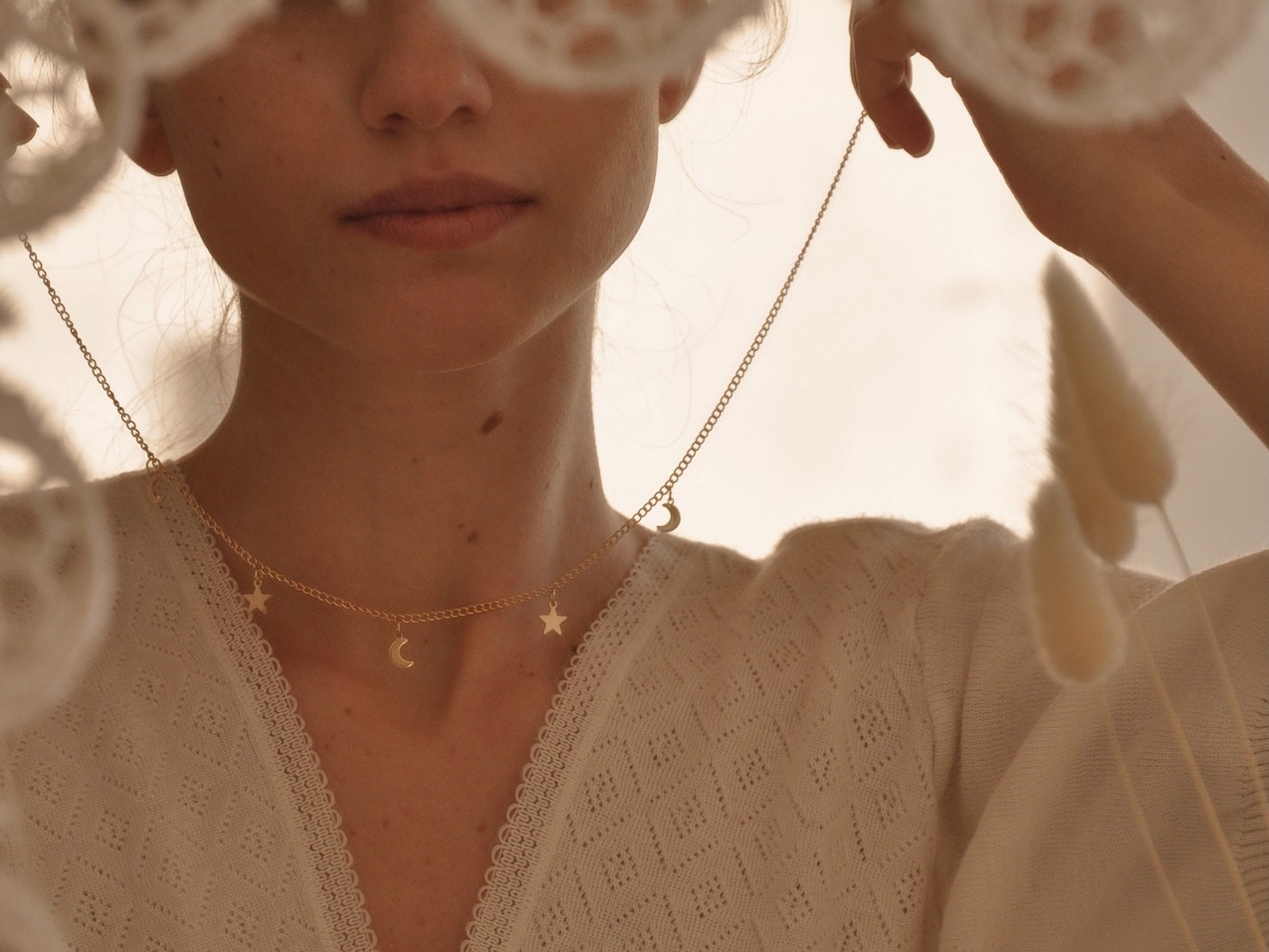 Woman holding golden necklace in her hands.