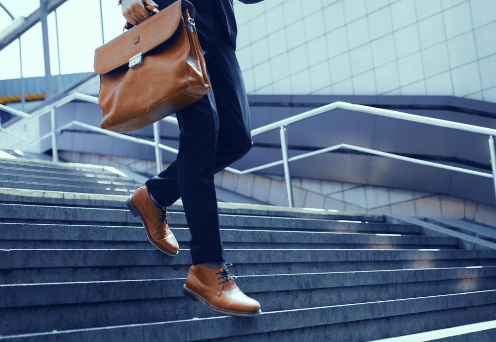 Businessman with bag in his hand walking down steps