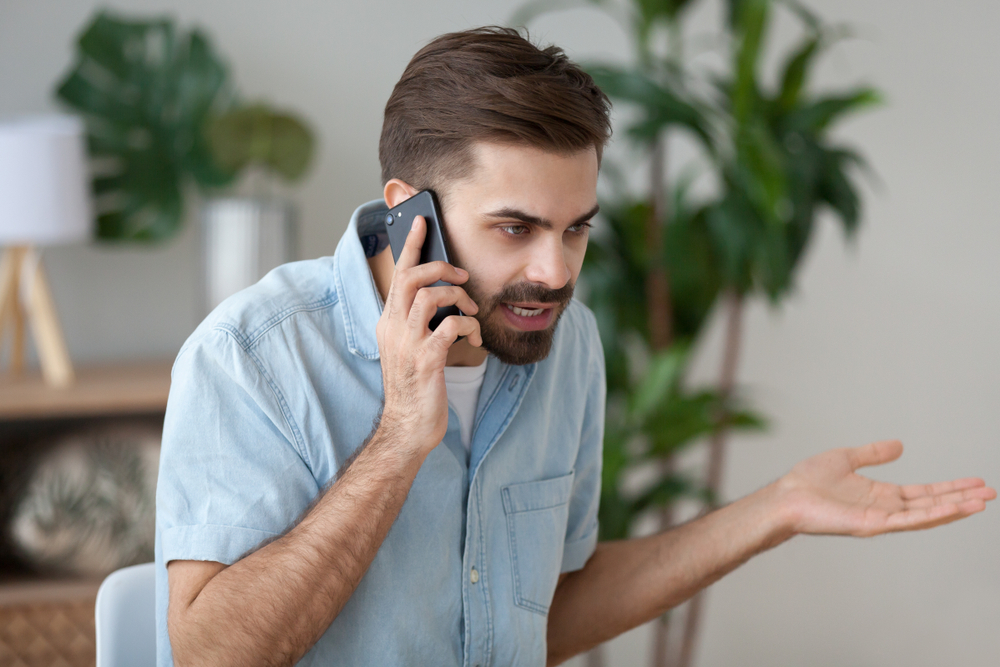irritated male have cell phone conversation to manage work trouble