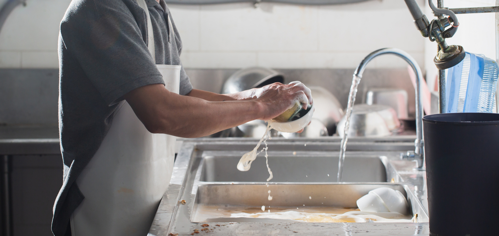 Man washing dishes in sink