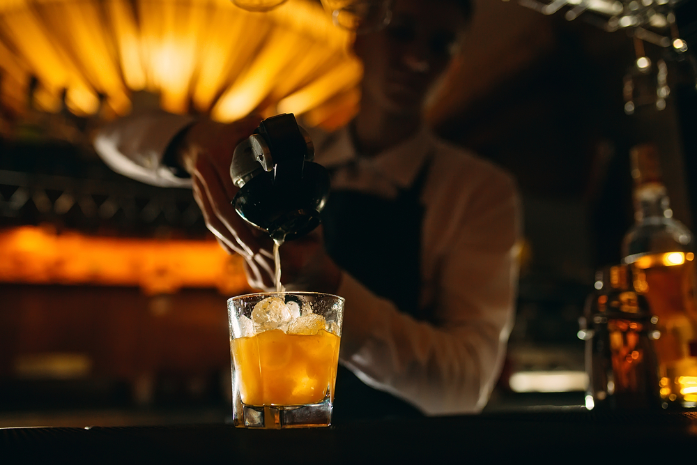 A bartender squeezes citrus juice