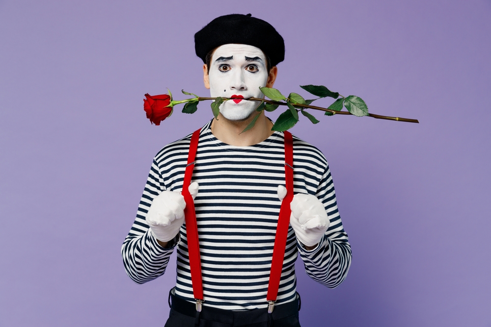 Full size body length romantic young mime man with white face mask wears striped shirt and a beret