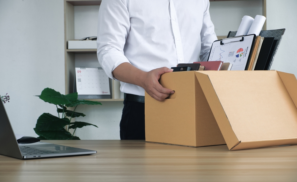 Man in white shirt quit job and is collecting belongings form office