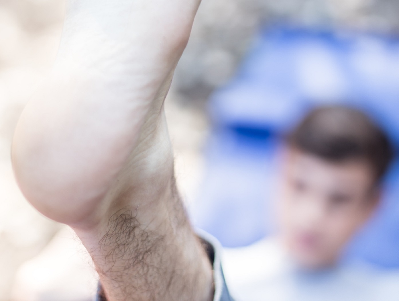 Man laying in the blurred background and keep his feat up in front.