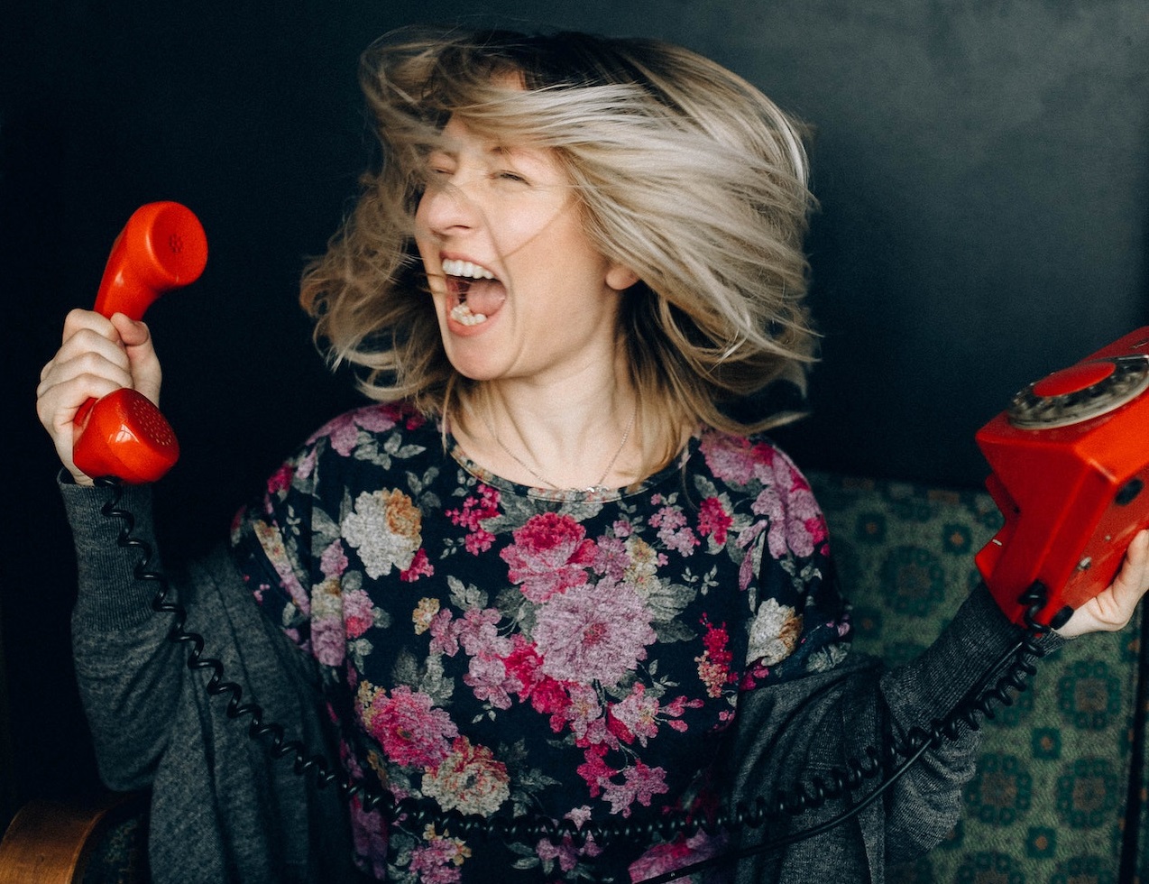 Woman screaming and holding a telephone.