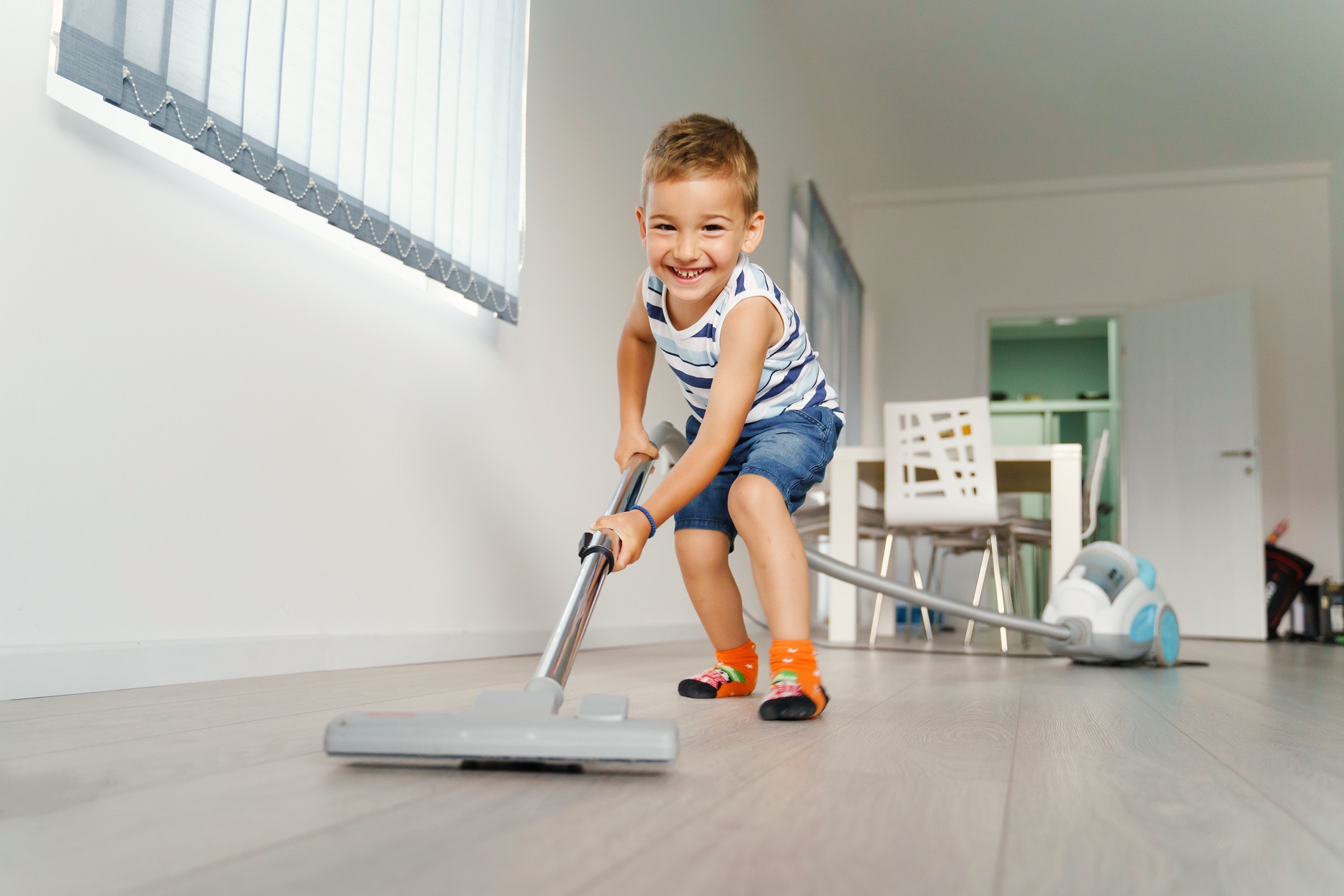 Little kid using vacuum cleaner.