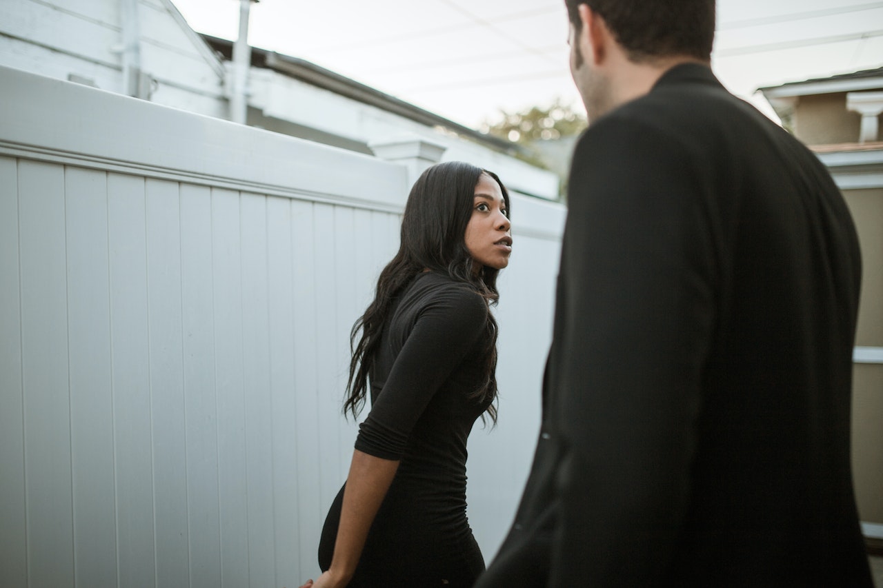 Black woman talking and walking off a man on the street.