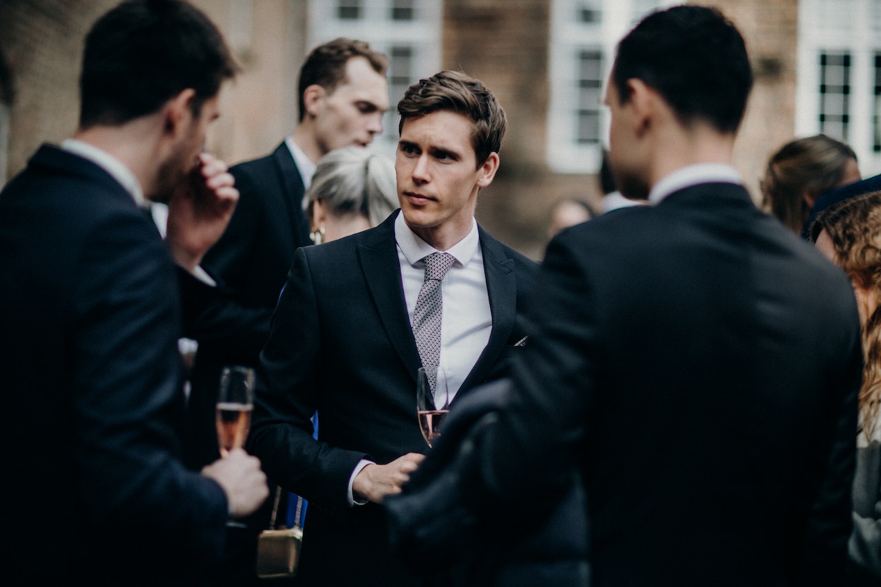 People at wedding ceremony talking and drinking wine.