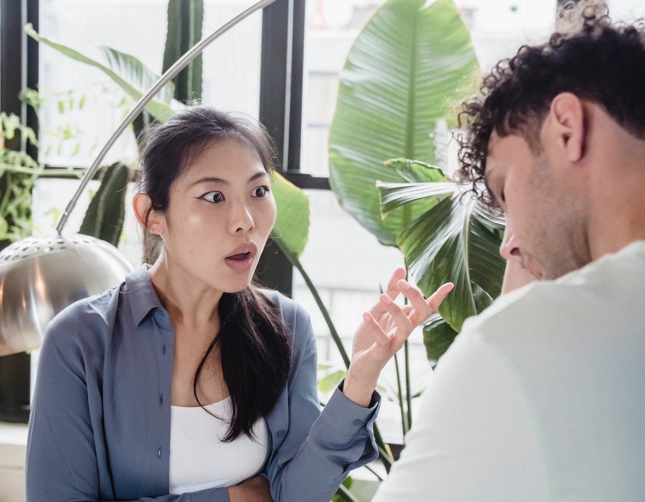 Woman looking shocked with man looking down.